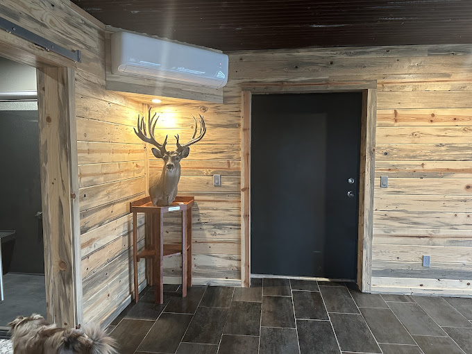 A room with wood walls and a deer head on the wall