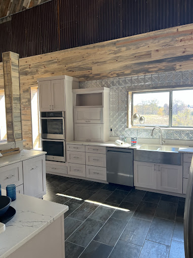 A kitchen with white cabinets and a large window