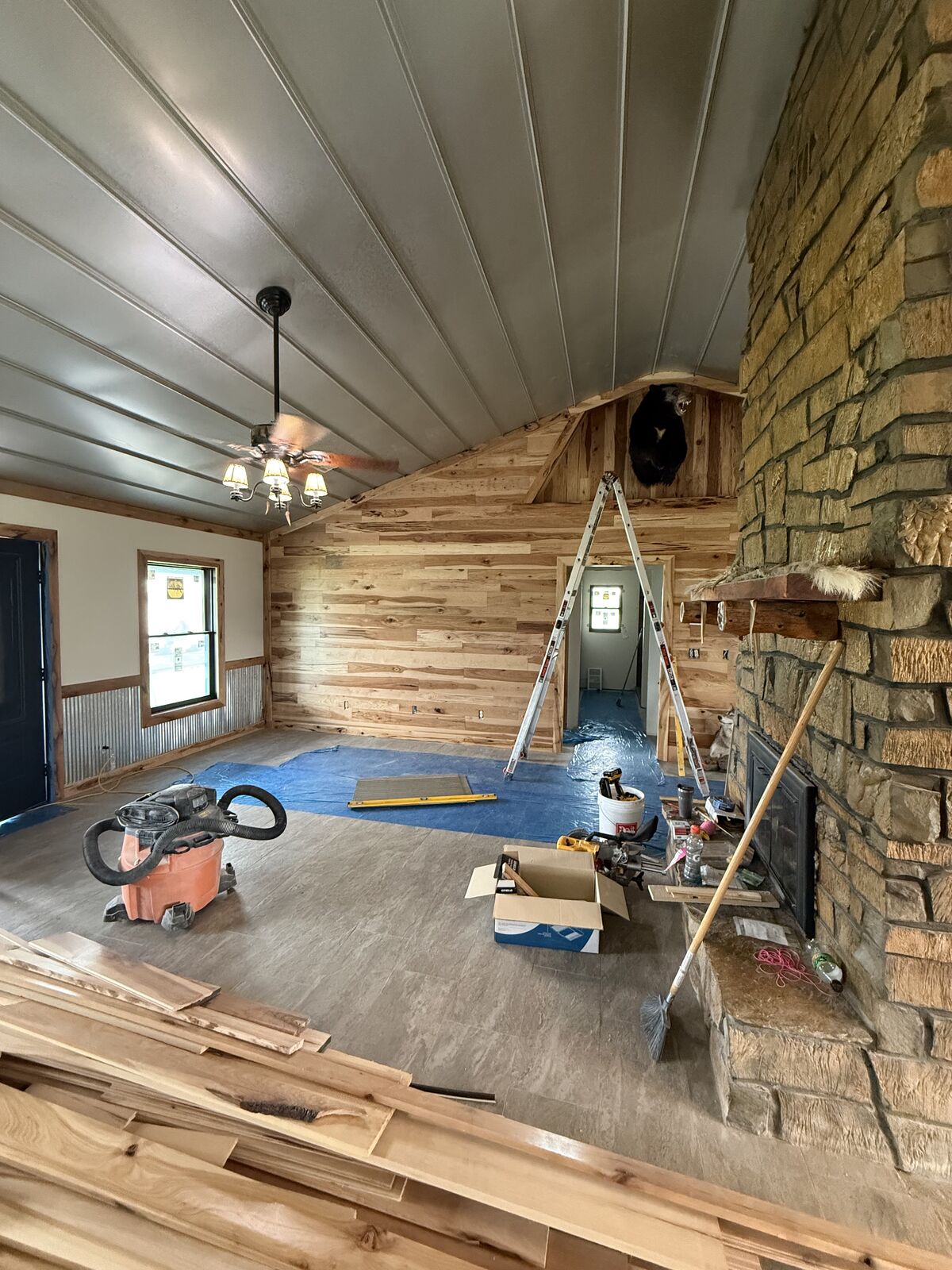 Barndominium living room with floor-to-ceiling stone fireplace and hickory accent walls in Oklahoma