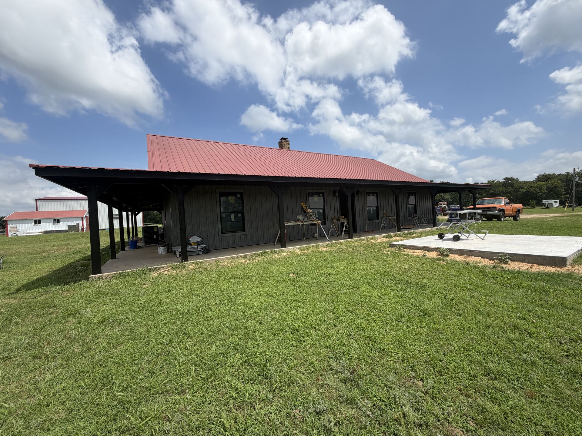 Custom barndominium with red metal roof built by Smith Construction Services near Seminole, OK