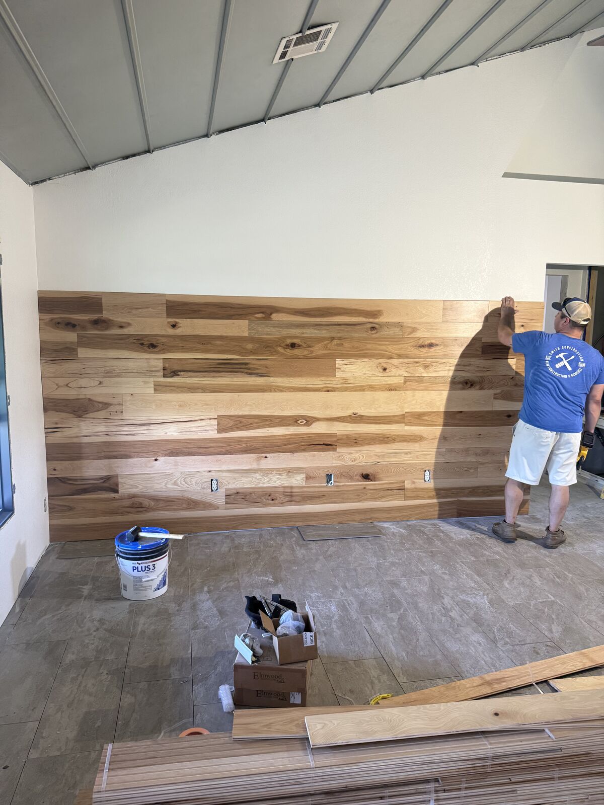 Carpenter installing custom wood accent wall during a remodel near Shawnee, OK