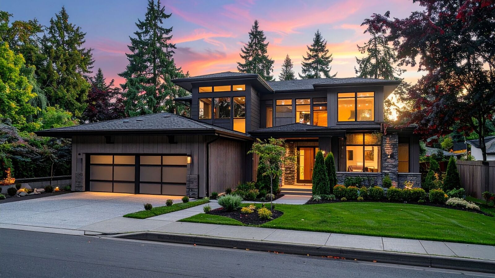 Custom two-story home exterior at dusk with landscaped front yard