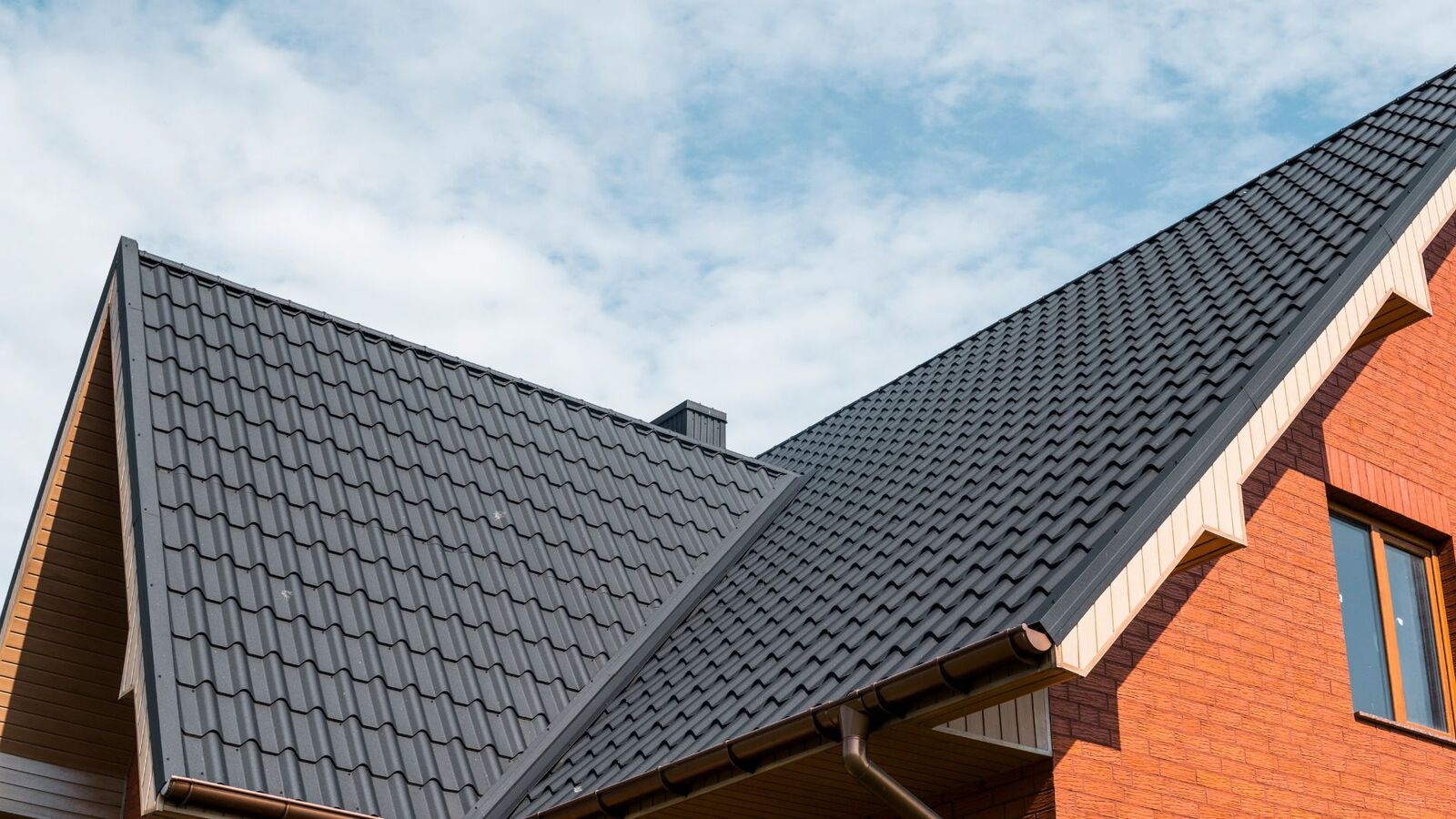 Dark metal roofing installed on a brick home