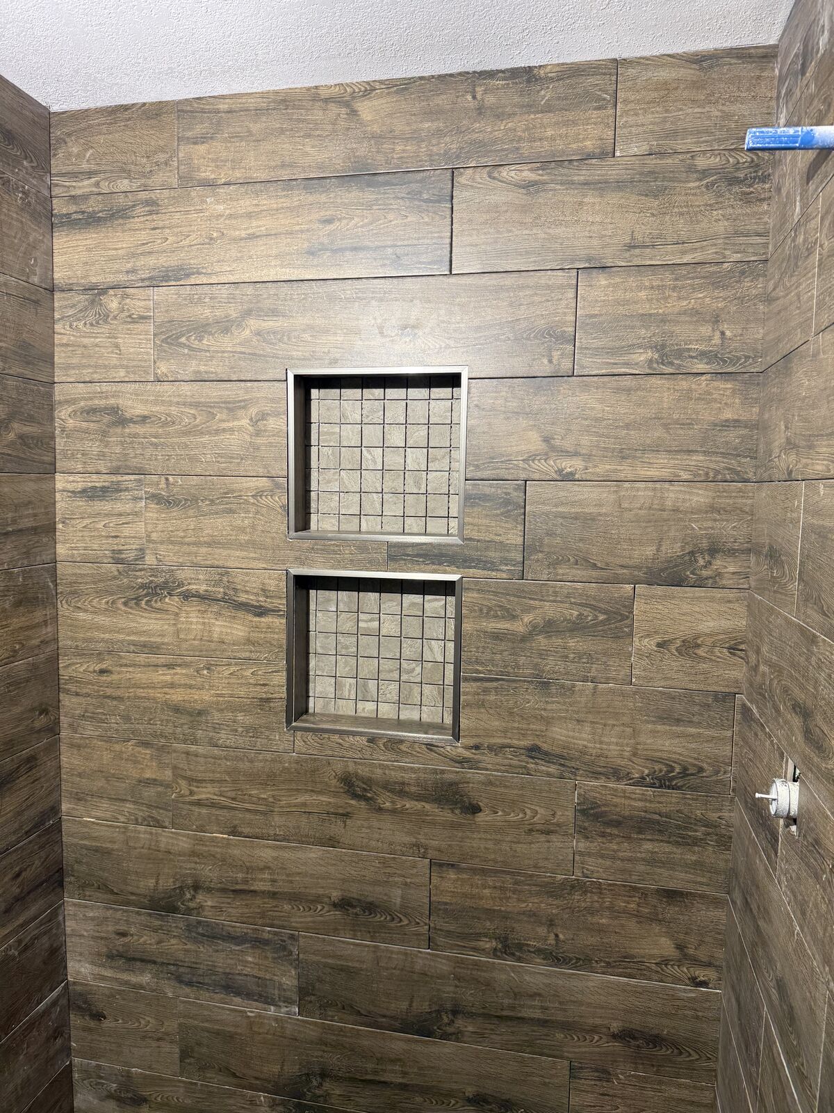 Walk-in shower with wood-look tile and built-in niches from a bathroom remodel near Shawnee, OK